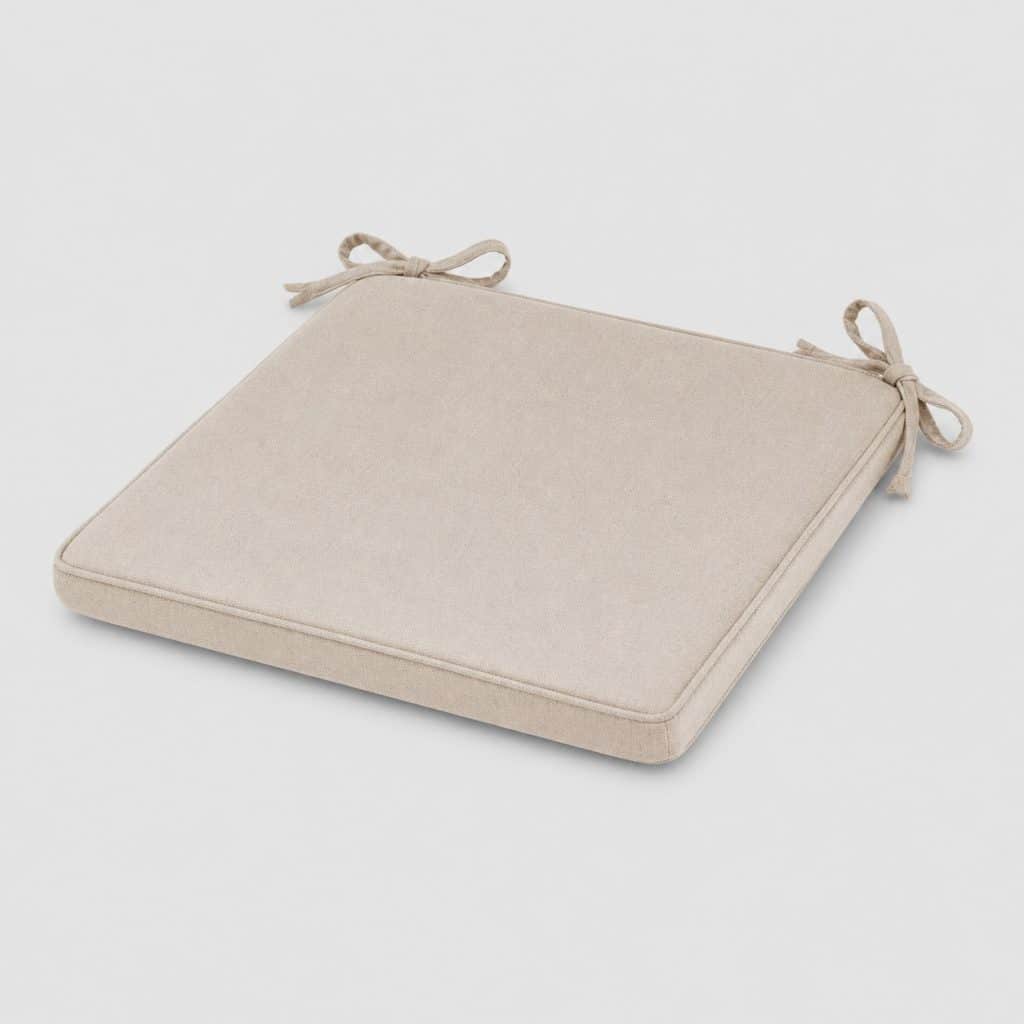 Coussin de chaise déhoussable posé sur une chaise en bois