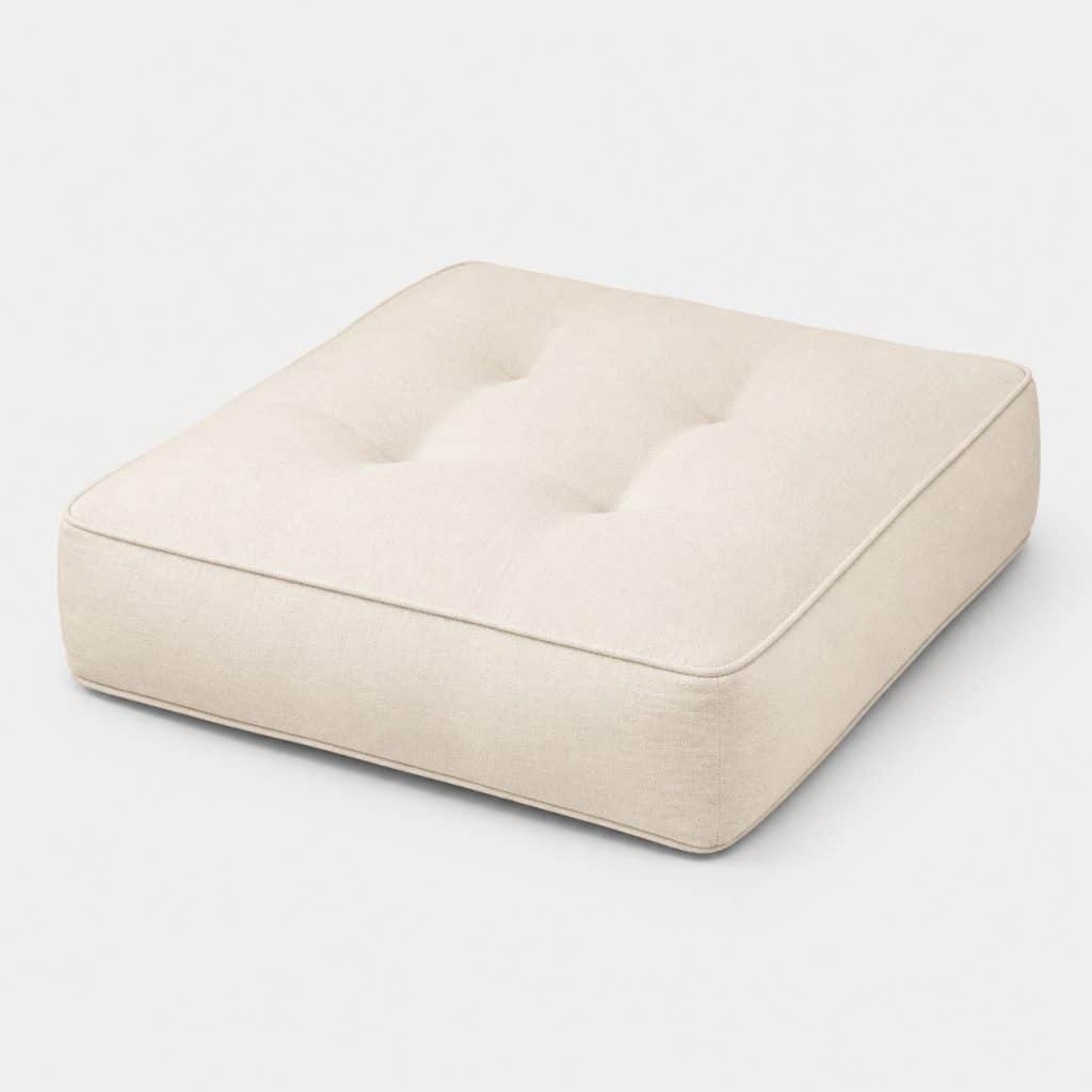 Coussin de sol en coton écru posé au salon